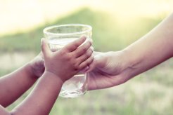 Image d'une maman qui donne un verre d'eau à son enfant