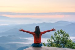 Femme qui prend l'air sur le sommet d'une montagne